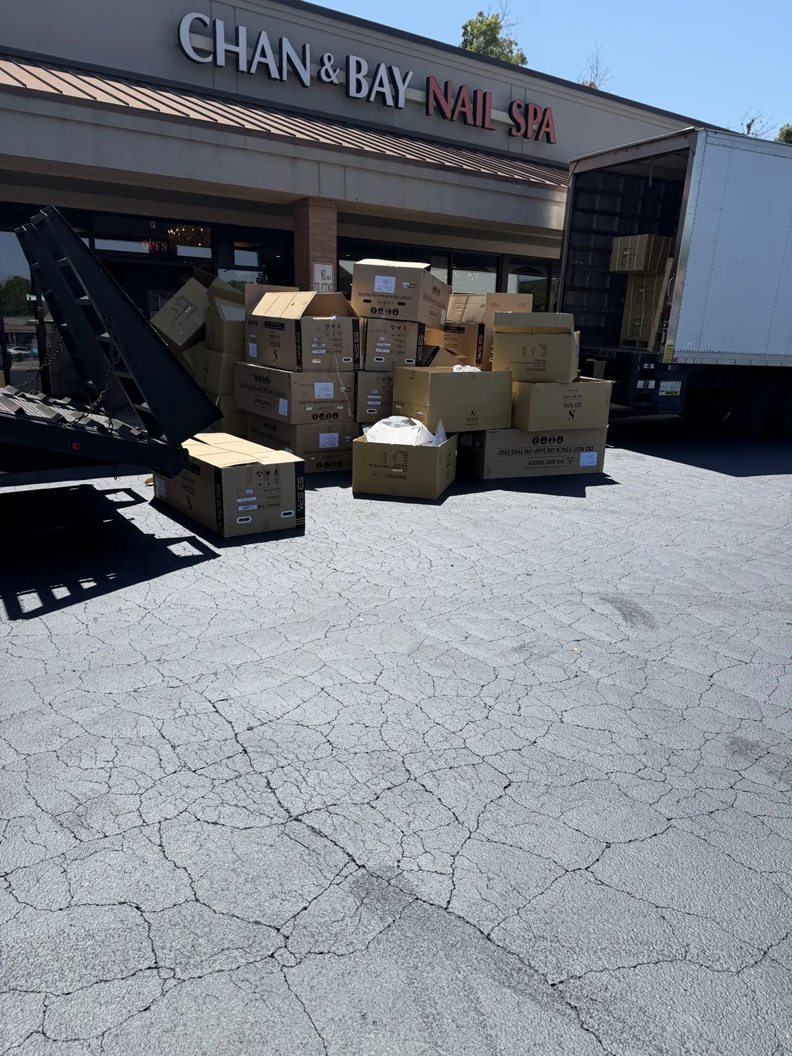 Large pile of cardboard boxes and commercial packaging staged outside a retail business