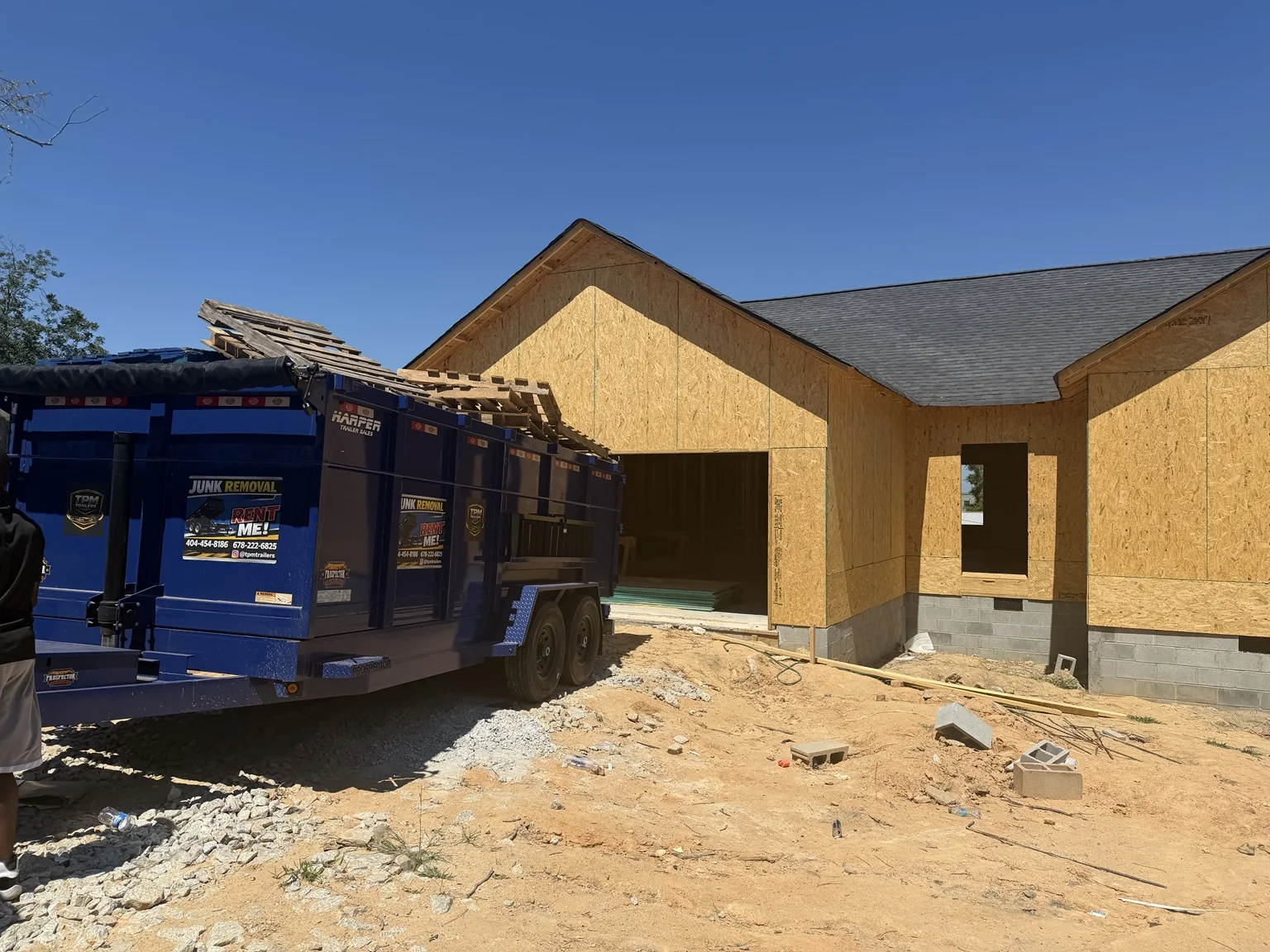 TPM Trailers dump trailer positioned beside a framed construction project