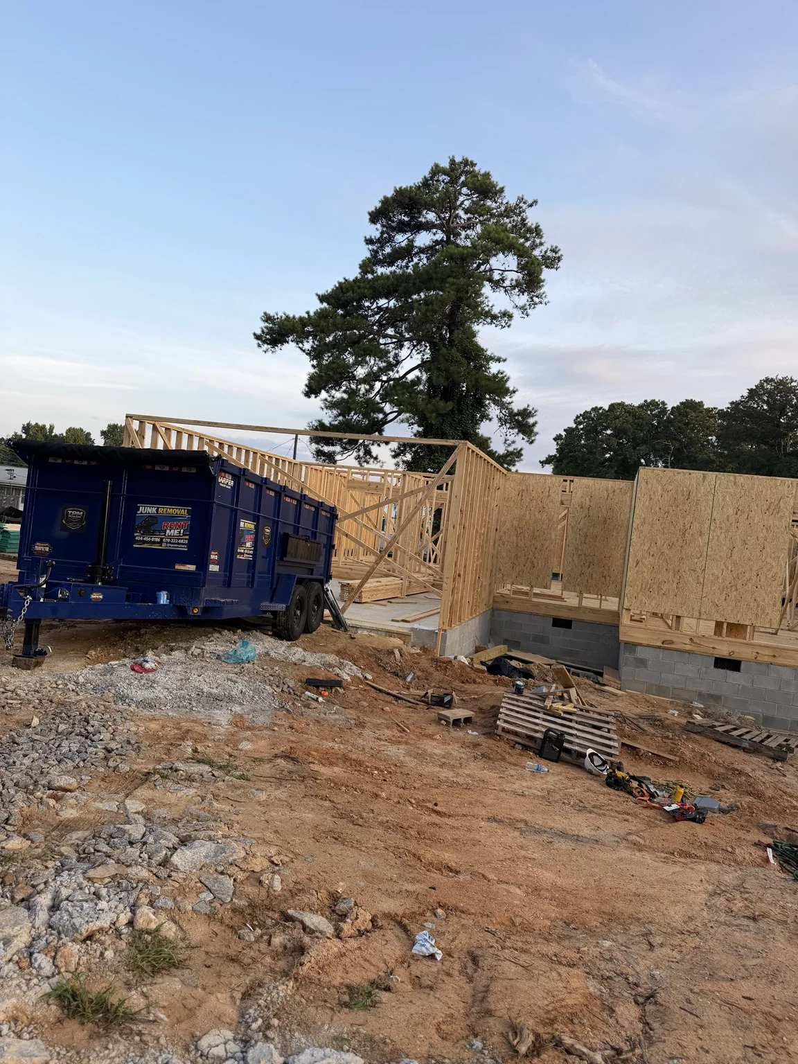 Wide view of Douglasville new construction framing with TPM Trailers dump trailer